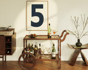 Framed number five art print hanging above a mid century bar cart.