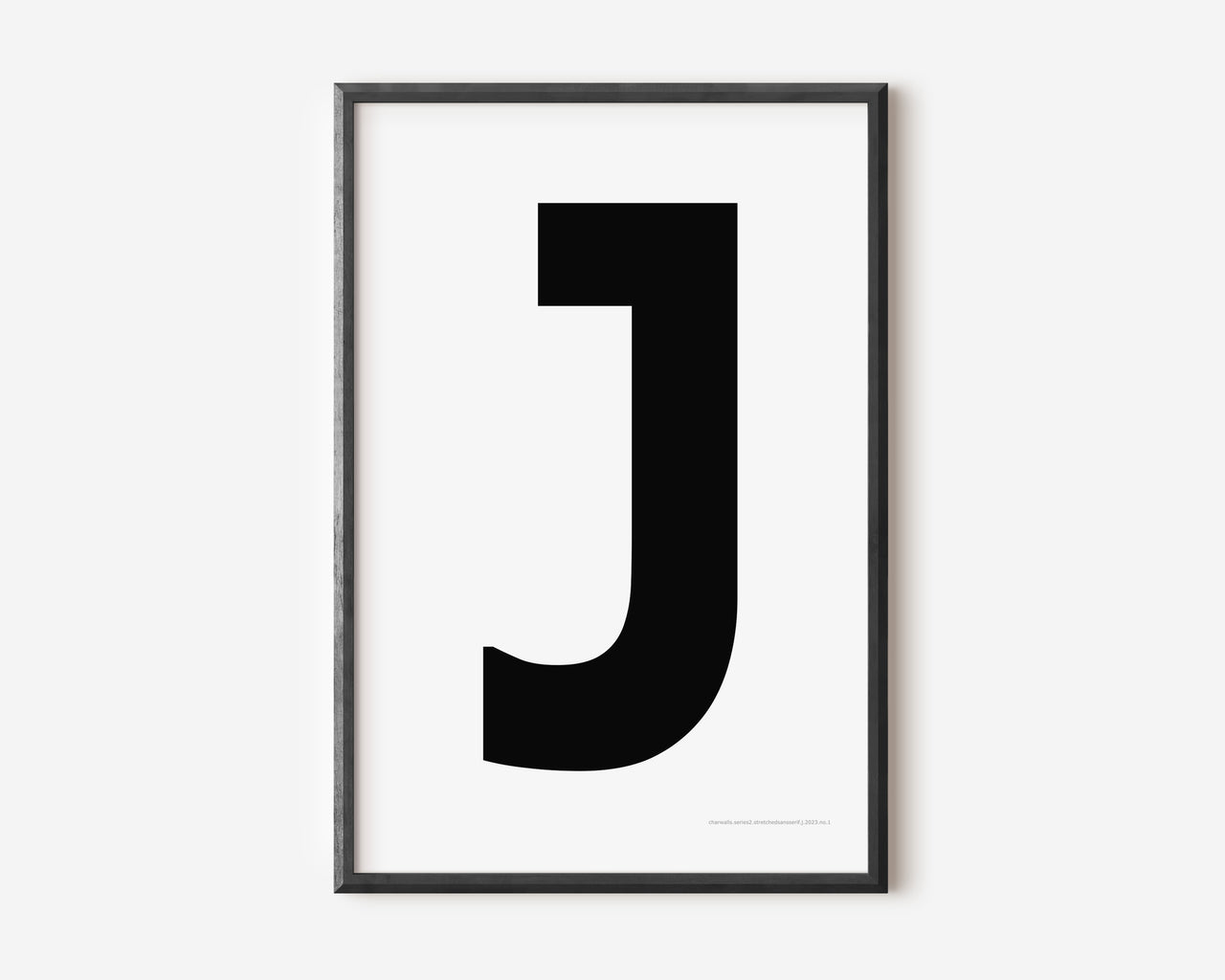 Modern art print with an uppercase black letter J on a white background.