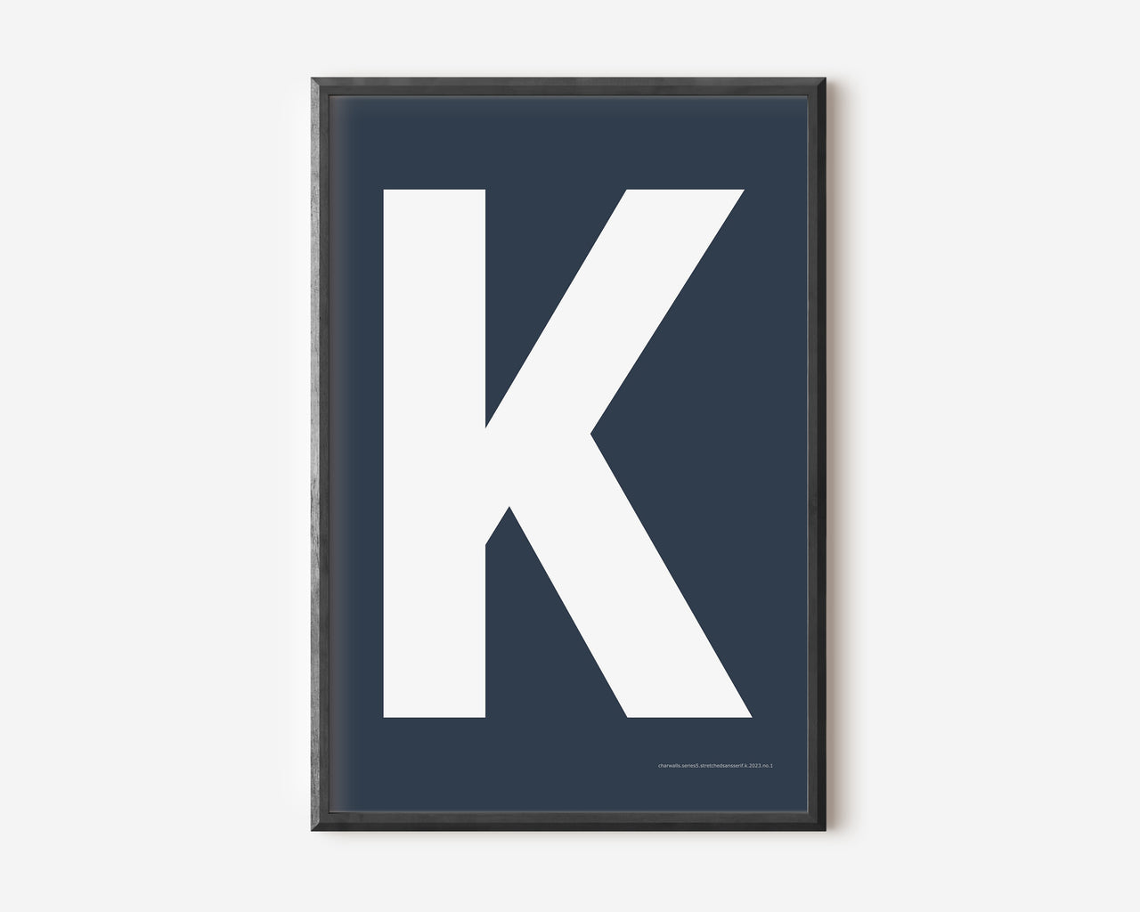 Modern art print with an uppercase white letter K on a navy blue background.