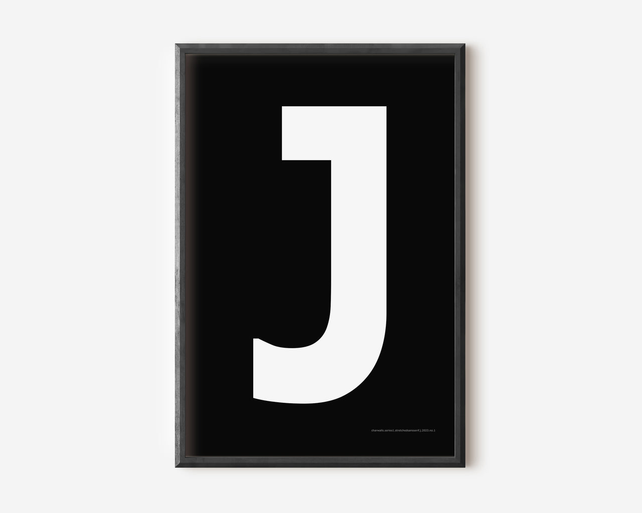 Modern art print with an uppercase white letter J on a black background.