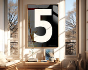 Oversized framed black and white number art print featuring the number 5 in a modern living room.