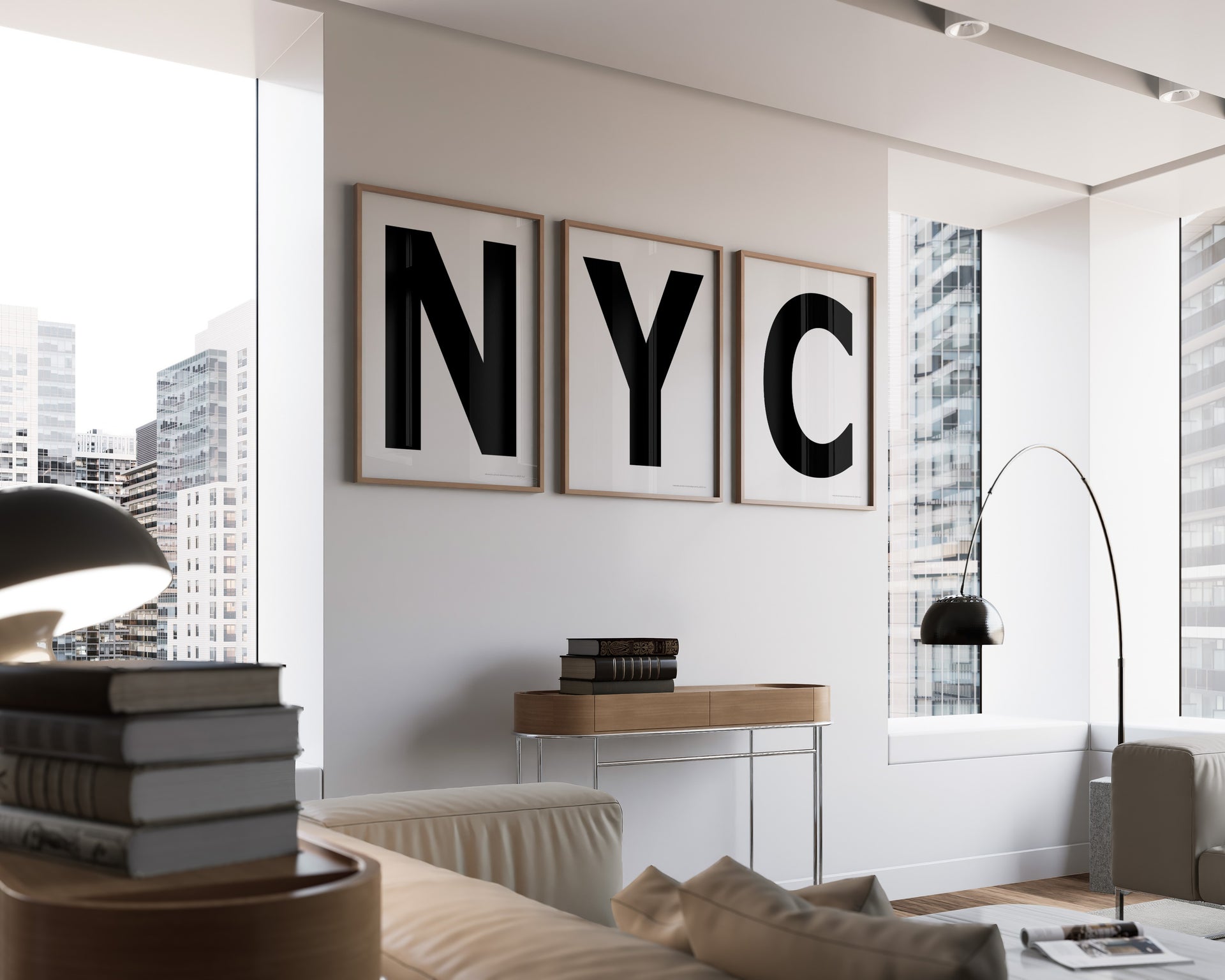 Three framed black and white letter art prints spelling out NYC hanging on a wall in a modern living room with a view of the city.