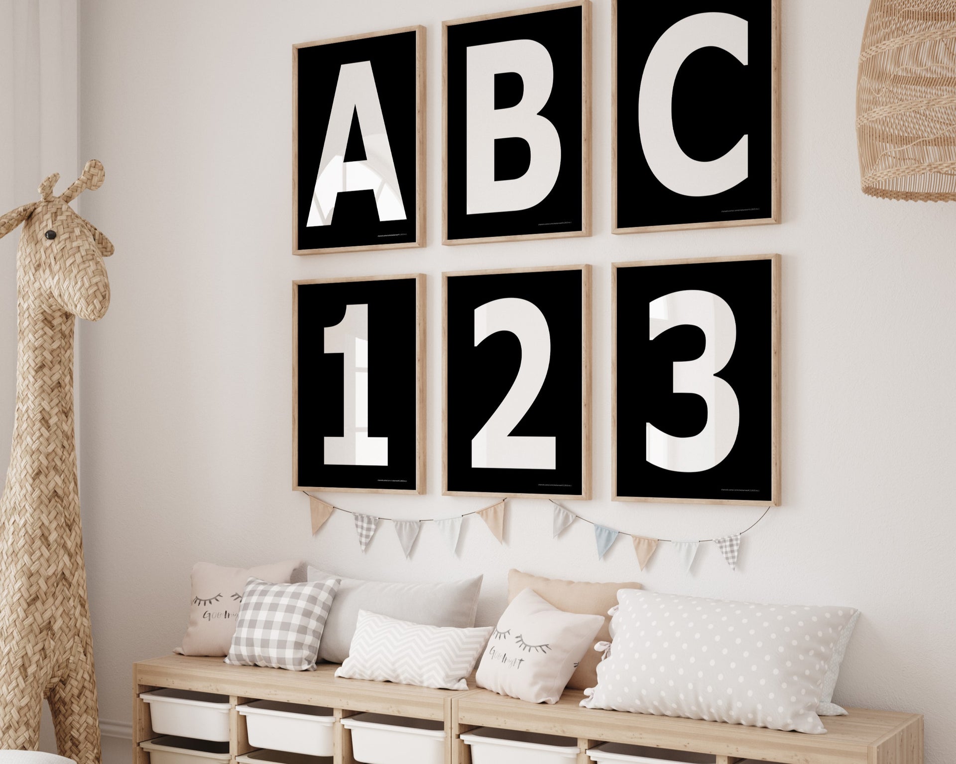 Six framed black and white letter and number art prints spelling out ABC123 hanging on a wall in a nursery or playroom.