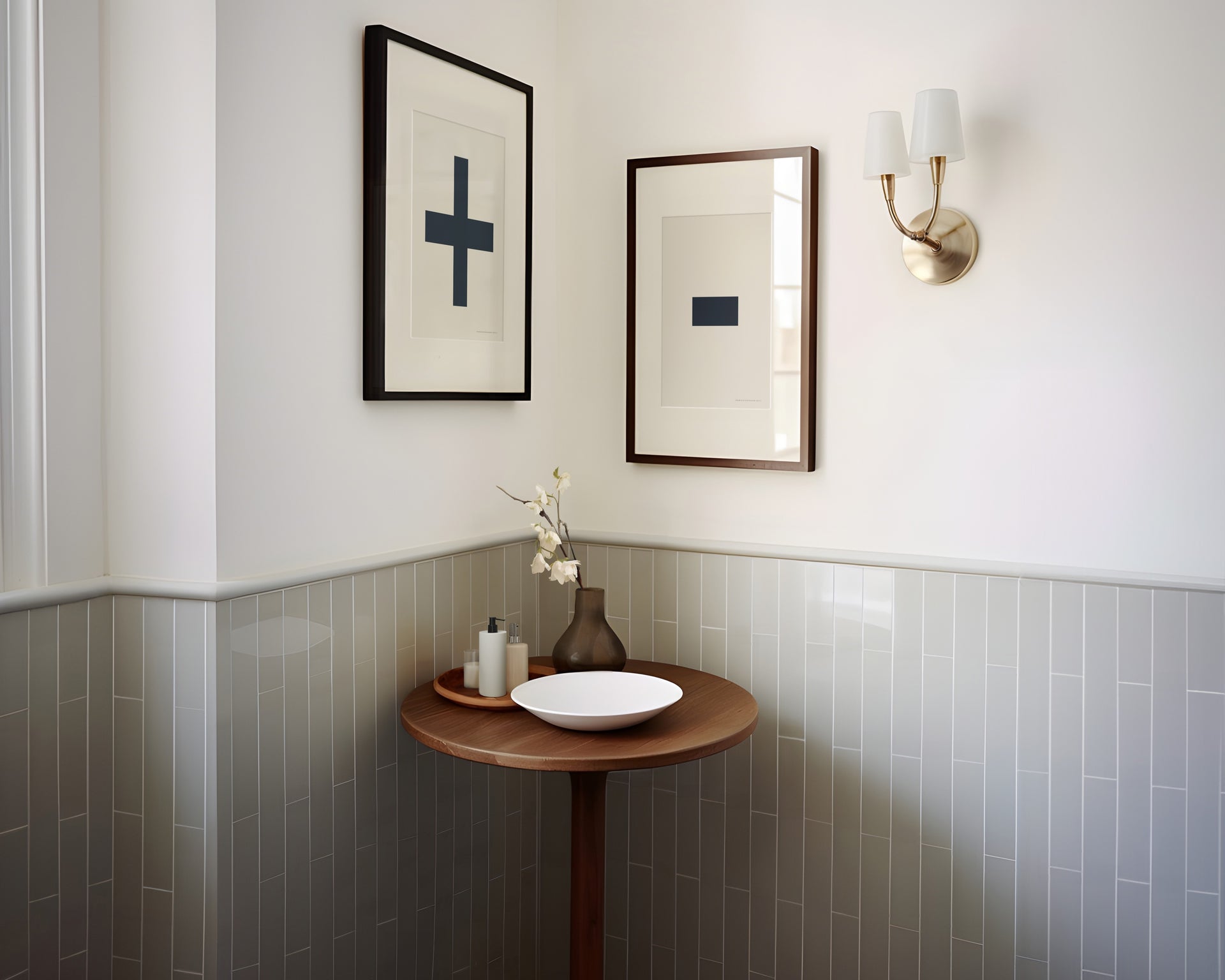 Two framed plus and minus art prints in a bathroom with green tile.